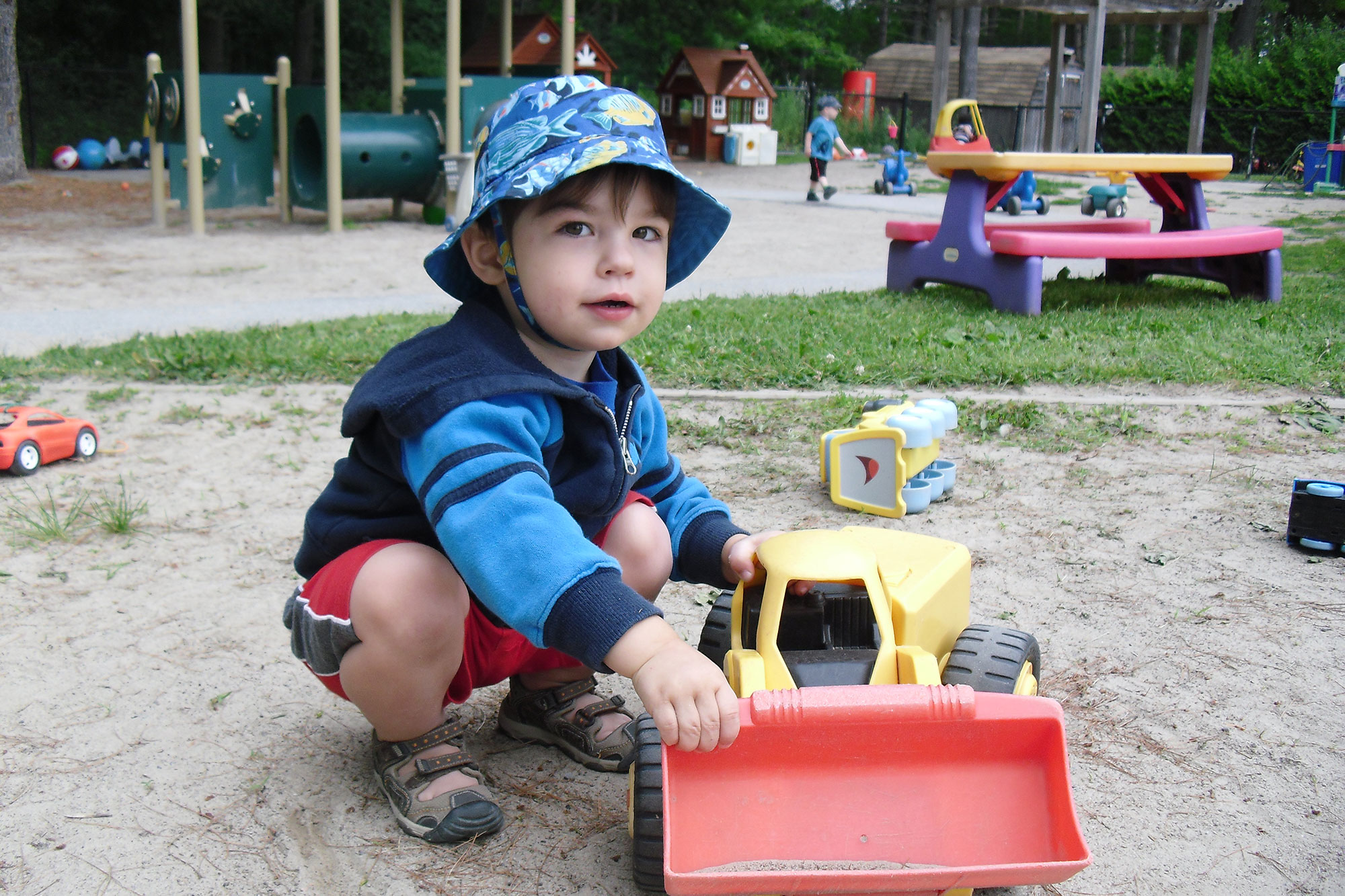 Boy playing with a truck in the sand