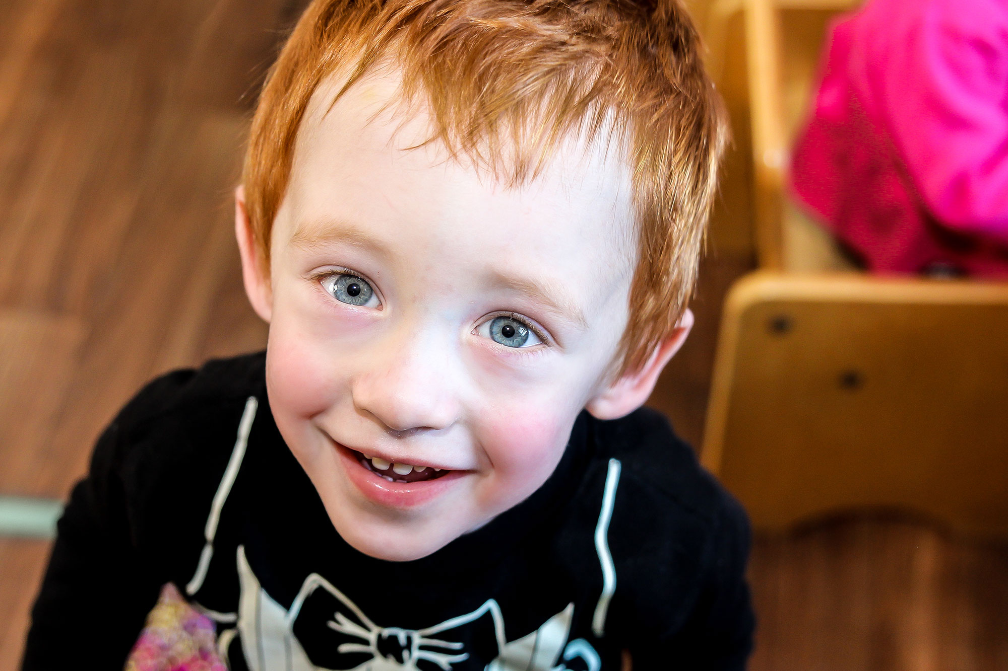 Red-headed little boy smiling at camera