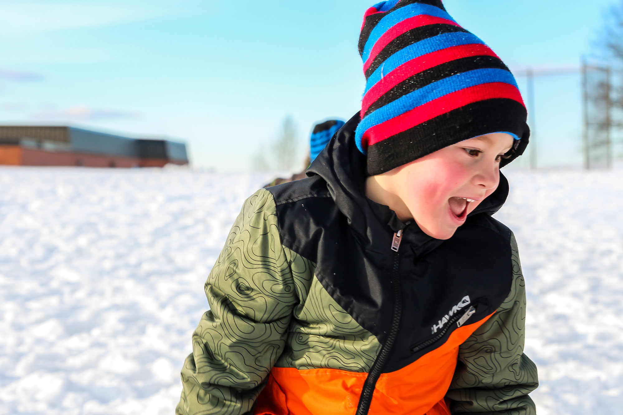 Boy outside in winter, wearing striped hat