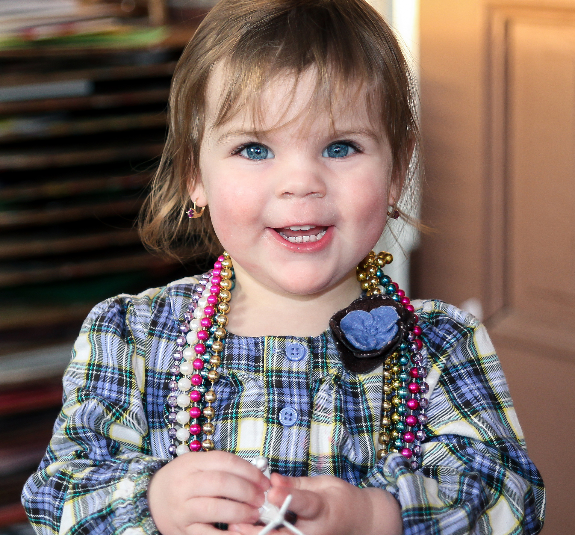 Girl in plaid dress smiling at camera