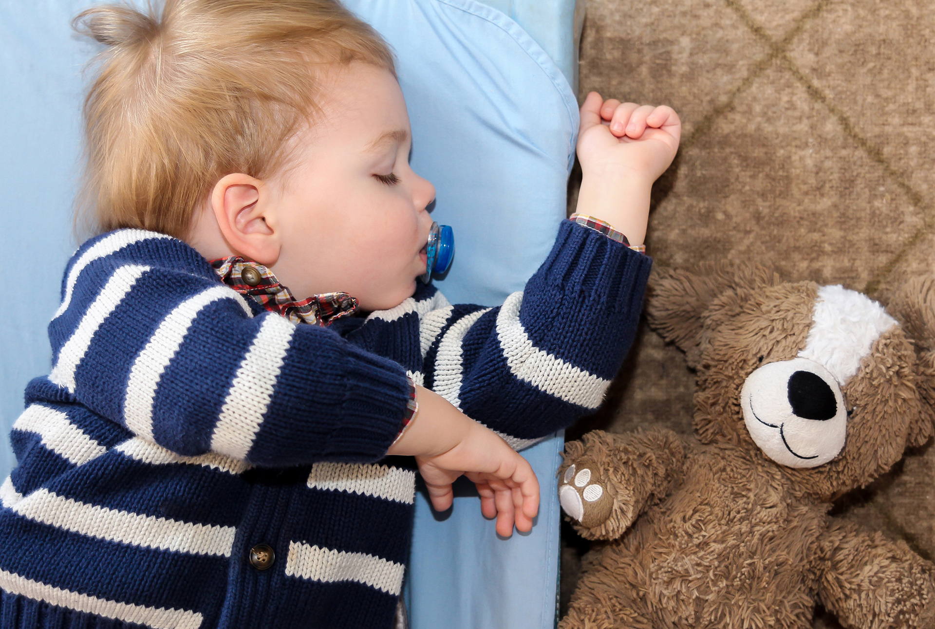 Boy sleeping with teddy bear